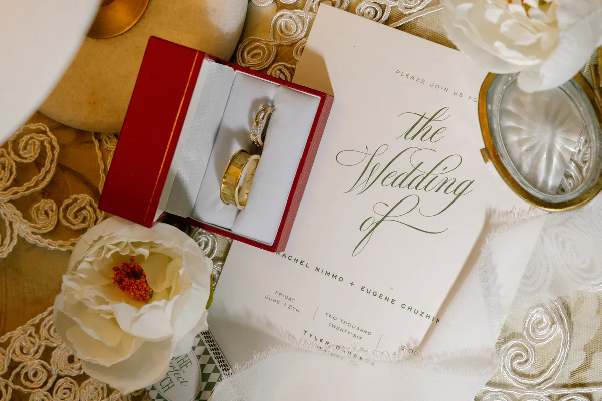 The wedding rings in their box beside the invitation suite